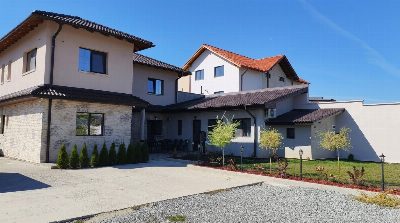 Overall view of Somni accommodation in Chinteni, with the courtyard and parking.